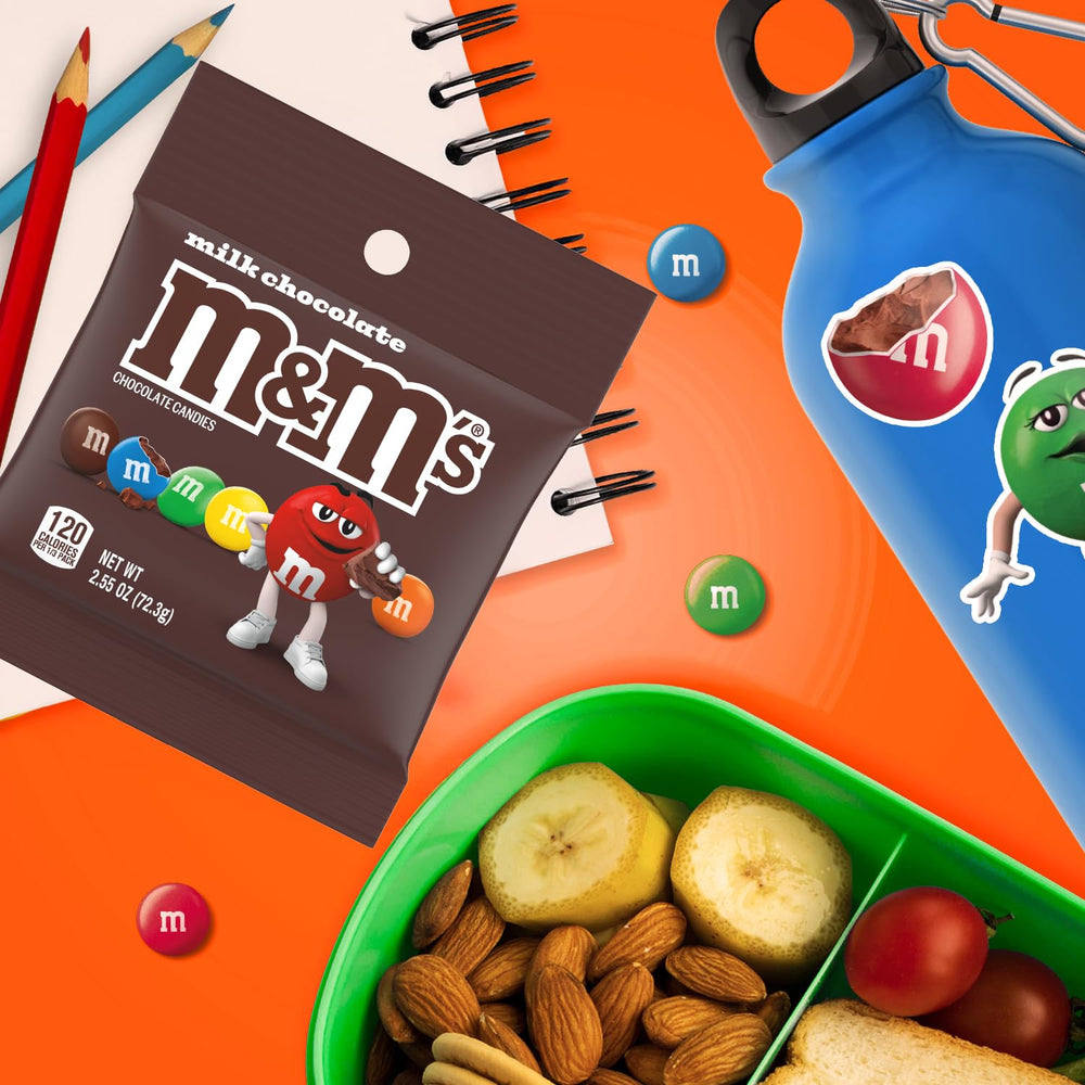 M&M'S on-the-go snack bags held in hand, perfect travel companion.