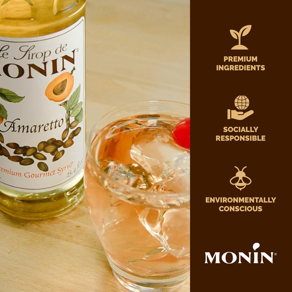 Monin Amaretto Syrup bottle beside a cocktail glass, elevating cocktails.