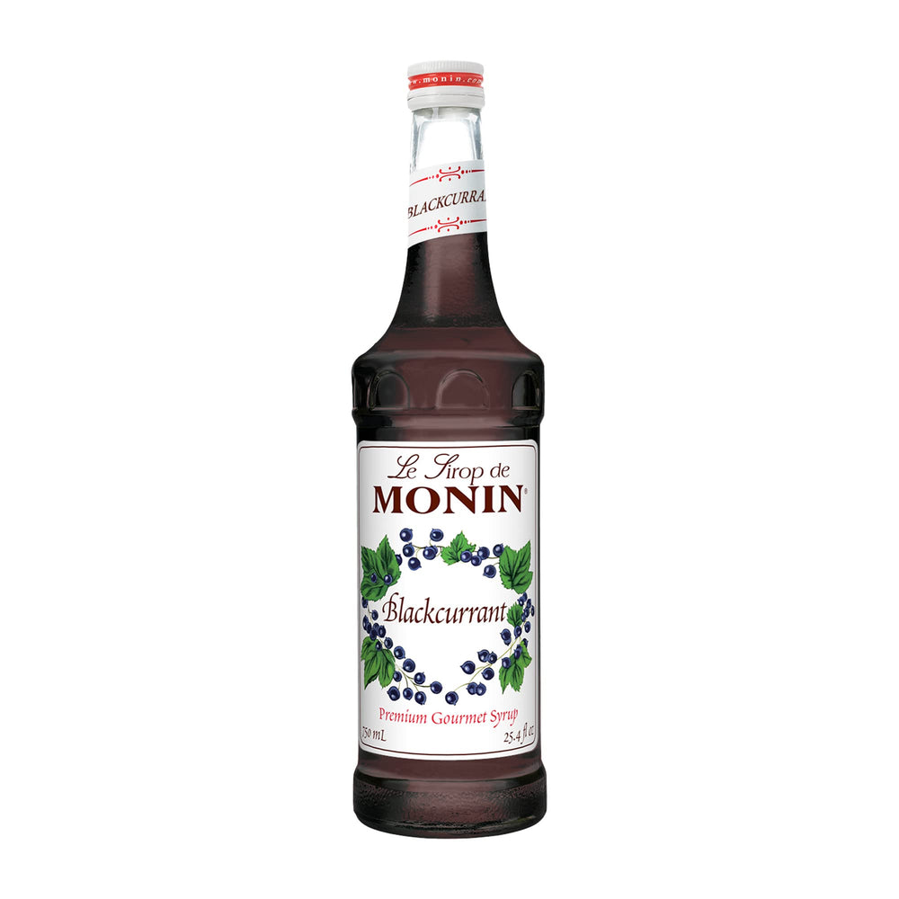 Monin Blackcurrant Syrup bottle on a bar enhances beverages.