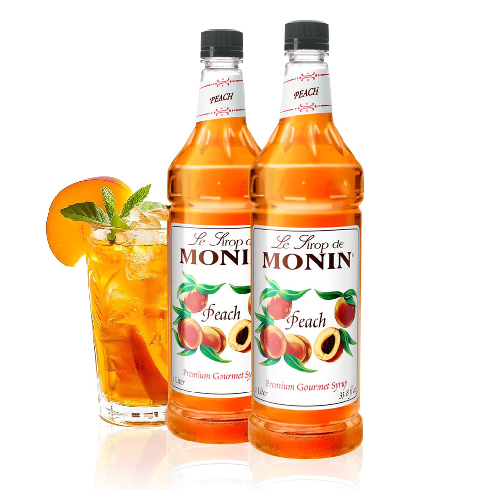 Monin Peach Syrup bottle on a kitchen counter highlighting authentic peach flavor for beverages.