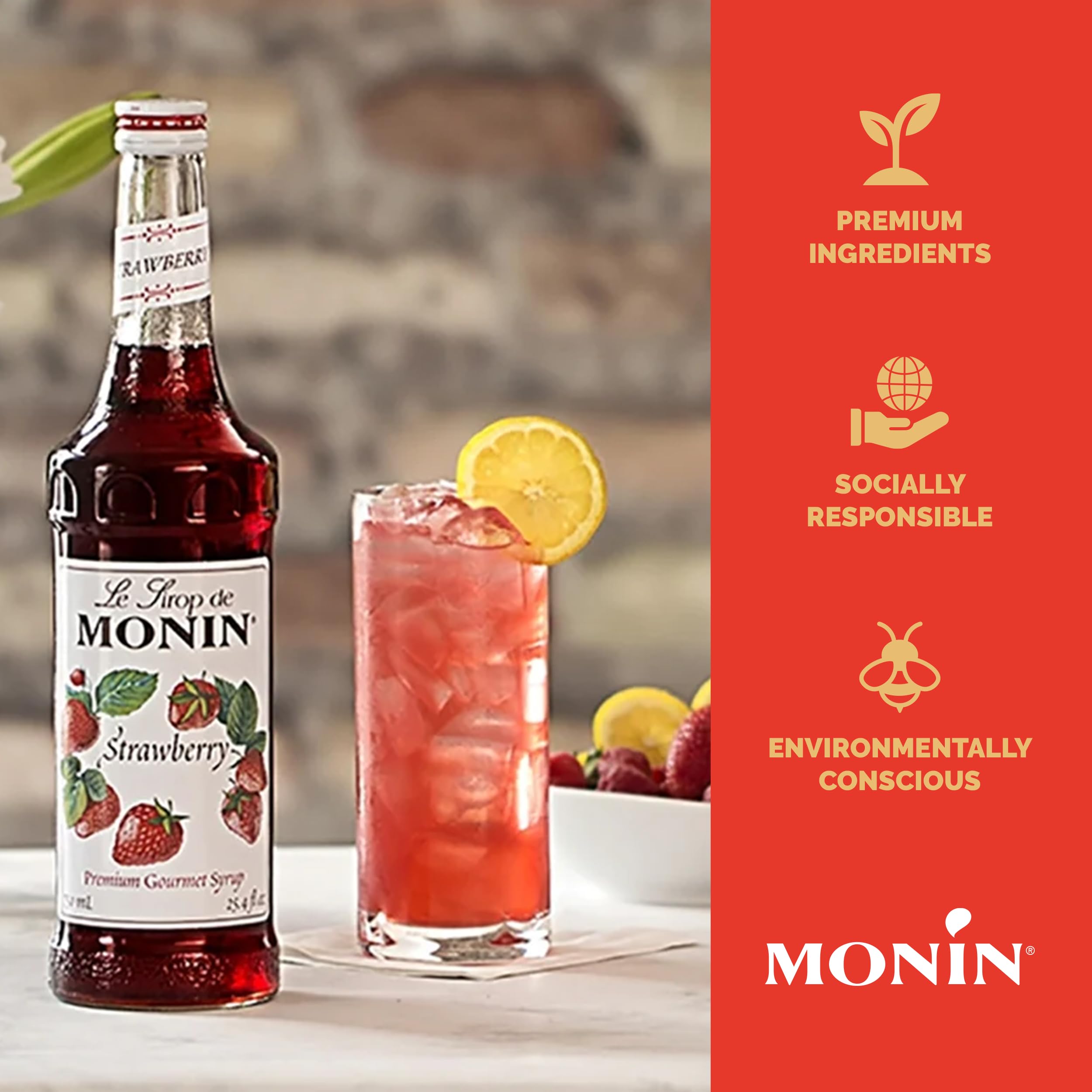Monin Strawberry Syrup beside a tea setup for flavored tea.