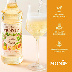 Close-up of Monin White Peach Syrup label highlighting gluten-free and non-GMO.