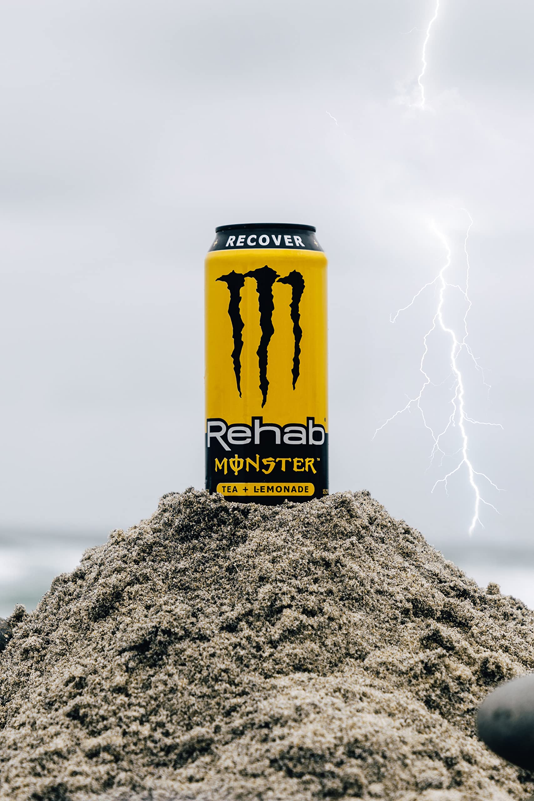 Monster Rehab Tea Lemonade on a supermarket shelf indicates a non-carbonated energy option.