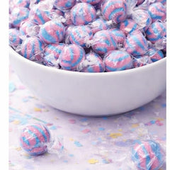 Bright carnival candy display with Munchique cotton candy balls on a buffet.