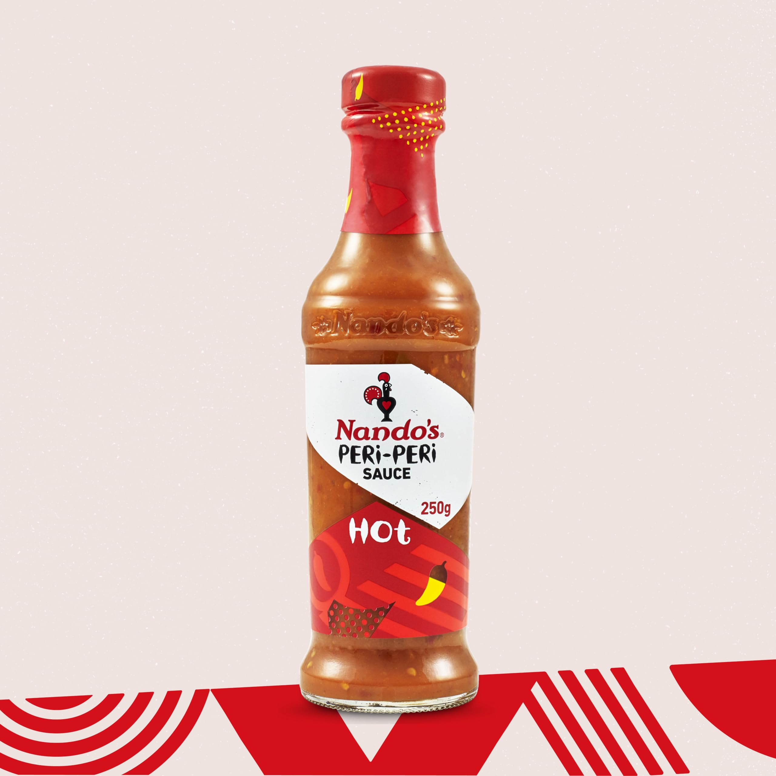 Nando's Hot Peri-Peri sauce bottle on table with tacos emphasizes versatile flavor.