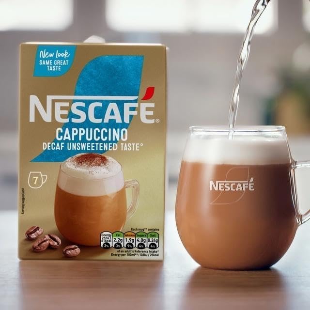 NESCAFÉ Cappuccino Decaffeinated sachet dissolving in hot water to create a cafe-style cup.