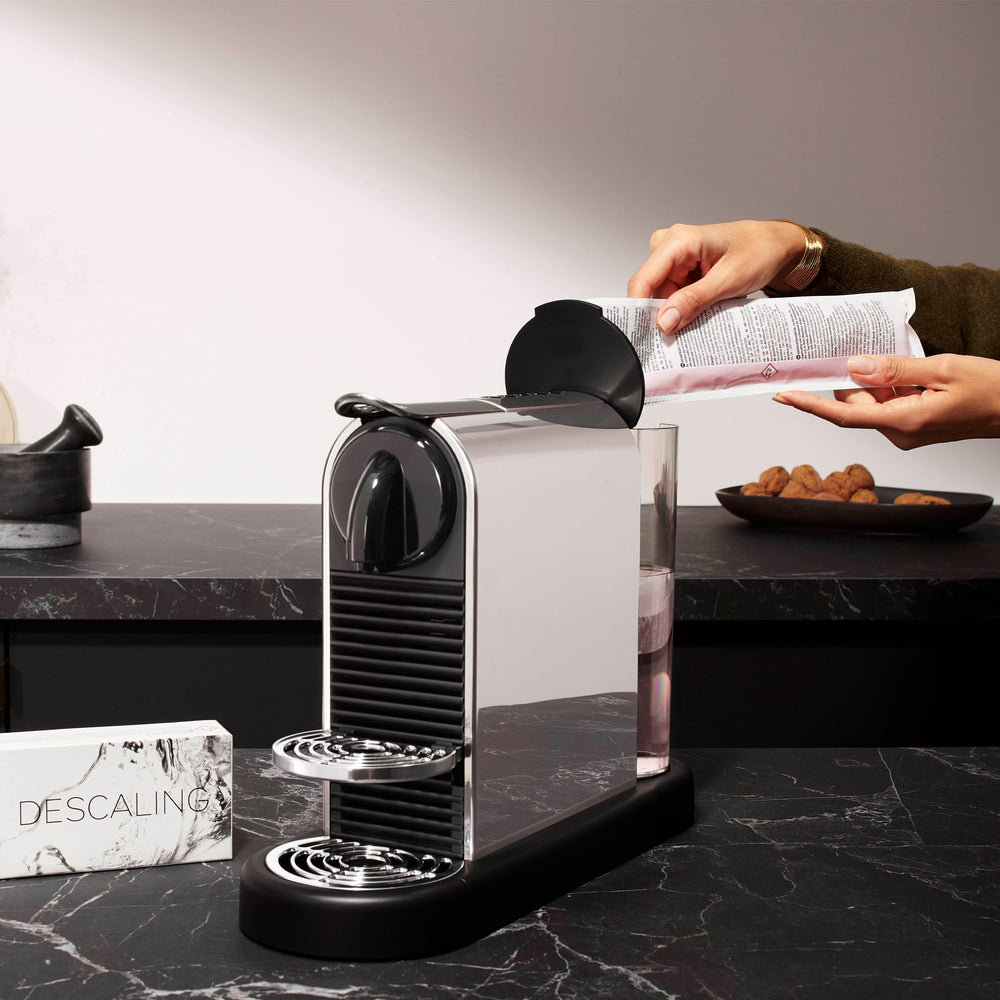 Nespresso descaling kit with bottle and container showing placement