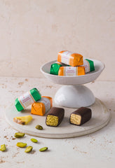 Niederegger pineapple-orange-pistachio-espresso marzipan coated in chocolate, vibrant flavor options.