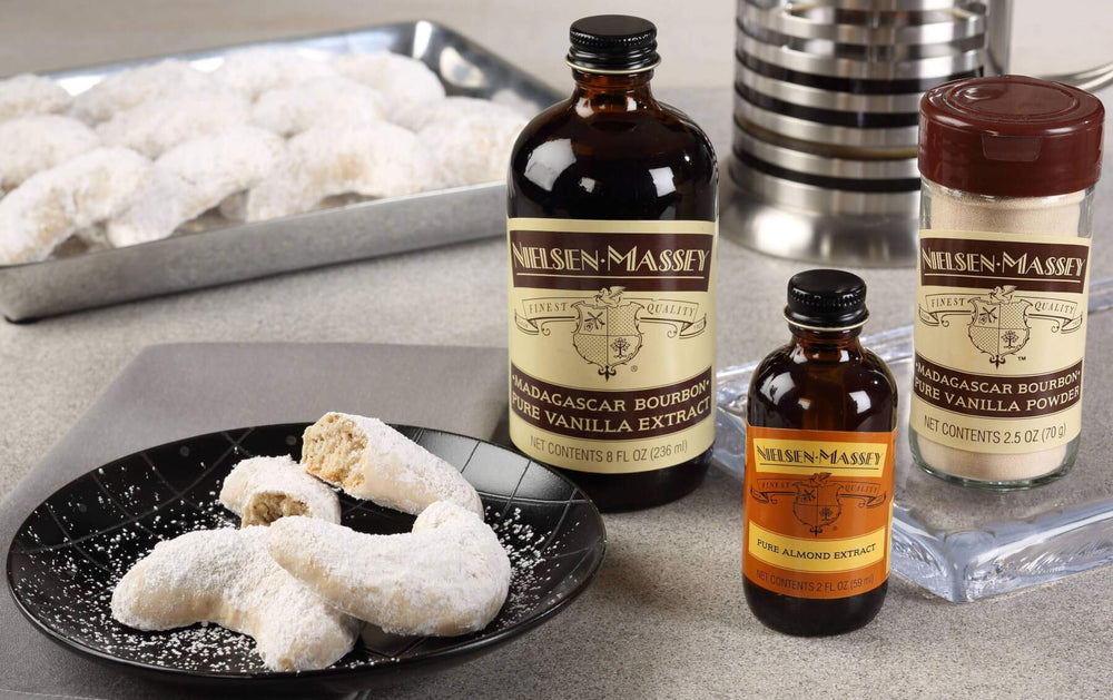 Nielsen-Massey Almond Extract on a baking or dessert setup