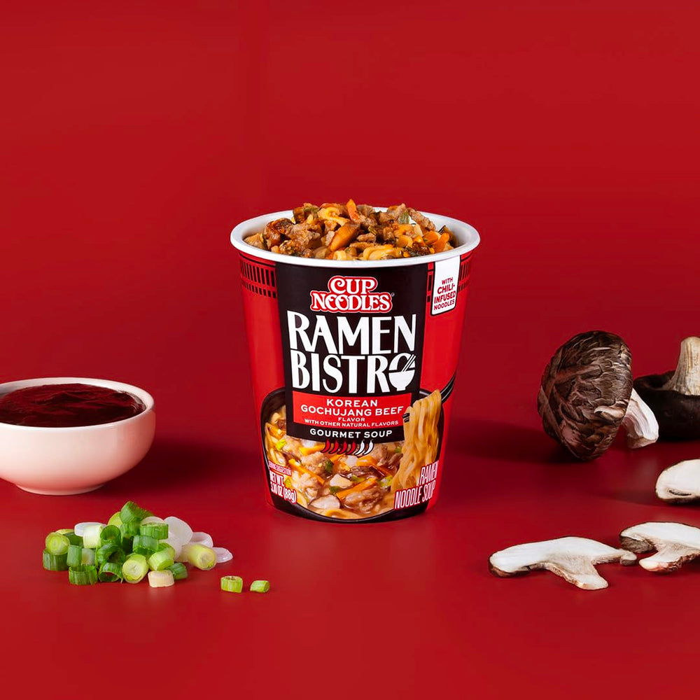 A bowl-level view of NISSIN Ramen Bistro with bok choy and vegetables.