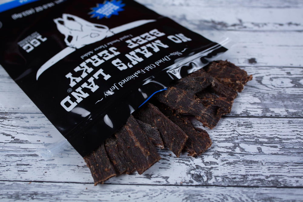 No Man's Land Beef Jerky in hand, ideal outdoor snack for energy.