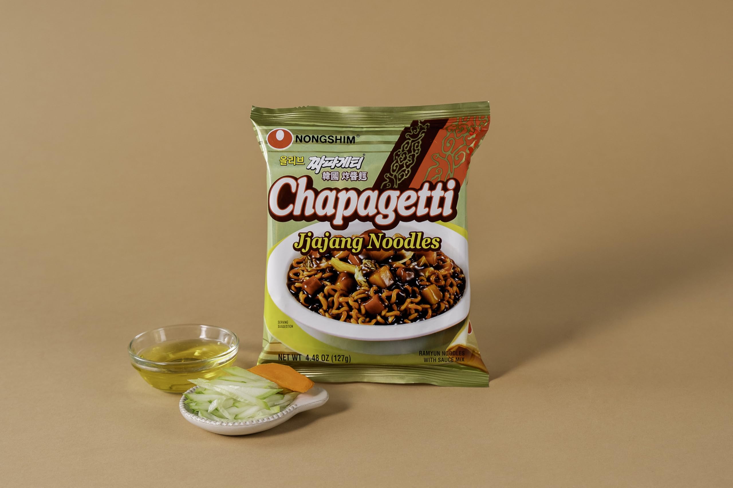 Close-up of Chapagetti ingredients: carrot and onion in sauce.