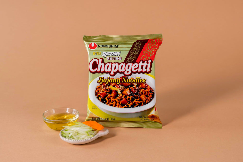 Close-up of Chapagetti ingredients: carrot and onion in sauce.