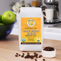 North Coast Half Moon beans in a scoop highlighting half-caff texture and shine