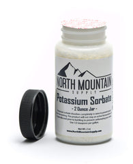 North Mountain Supply potassium sorbate jar showing the dosing spoon for precise 1/2 teaspoon per gallon.