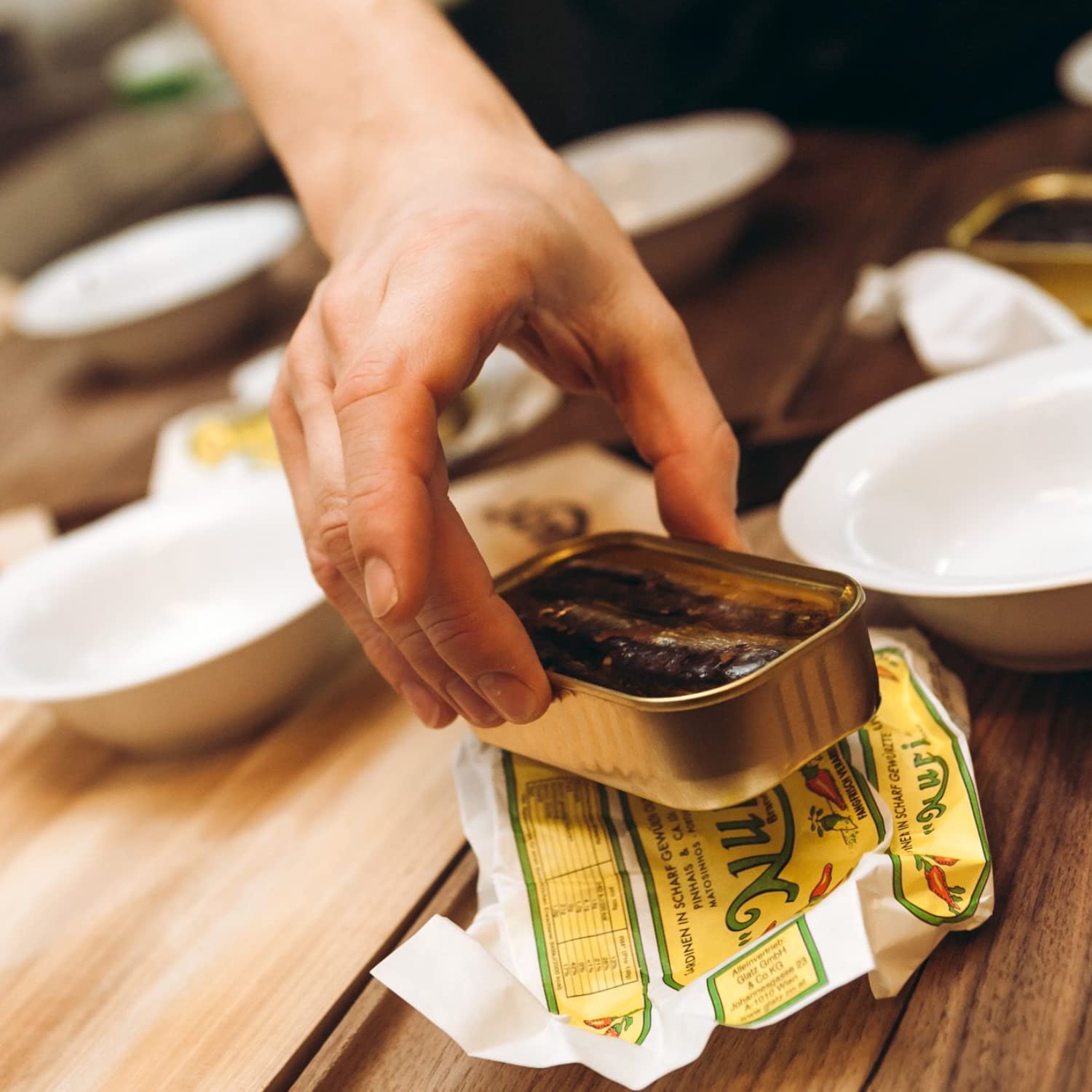 Nuri olive oil bottle beside sardines for dipping and cooking ideas