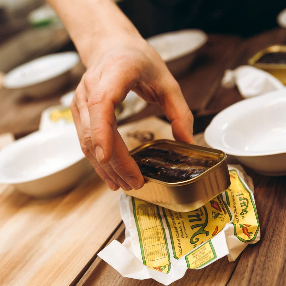 Nuri olive oil bottle beside sardines for dipping and cooking ideas