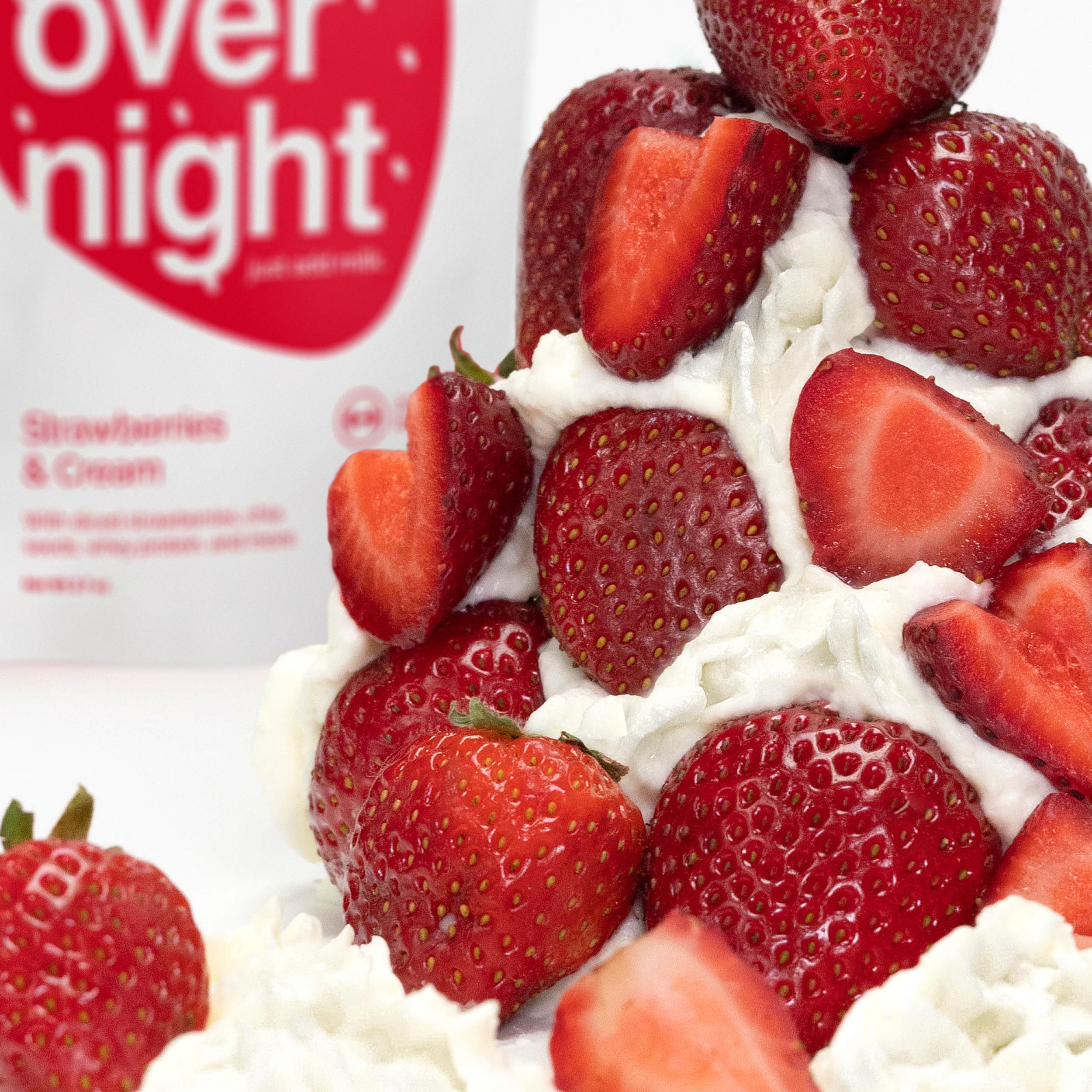 Oats Overnight Strawberries & Cream ingredients layout with real strawberries and chia seeds.