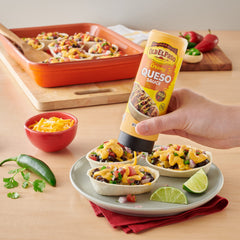 Old El Paso queso topping draped over loaded nachos.