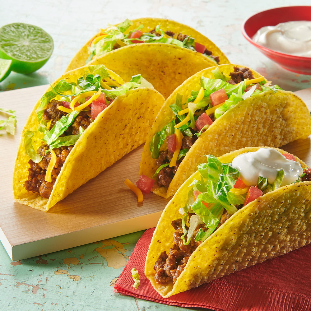 Seasoning shaken with ground beef in a skillet for tacos.