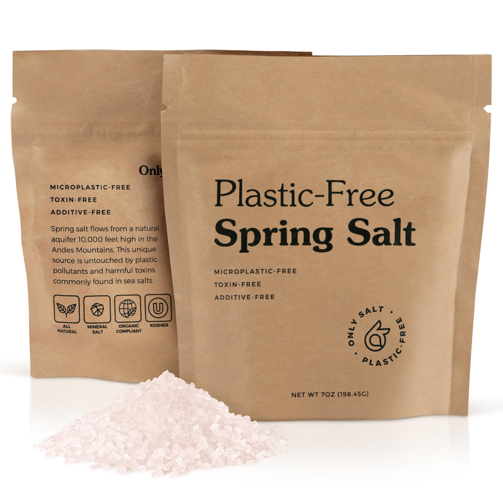 Only Ancient Spring Salt flakes spread on a surface with a subtle earthy glow.