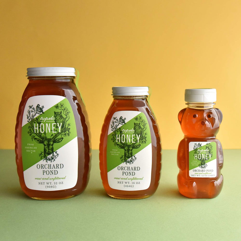 Close-up of pale olive-green hue in a glass Tupelo honey jar, delicate flavor hinted
