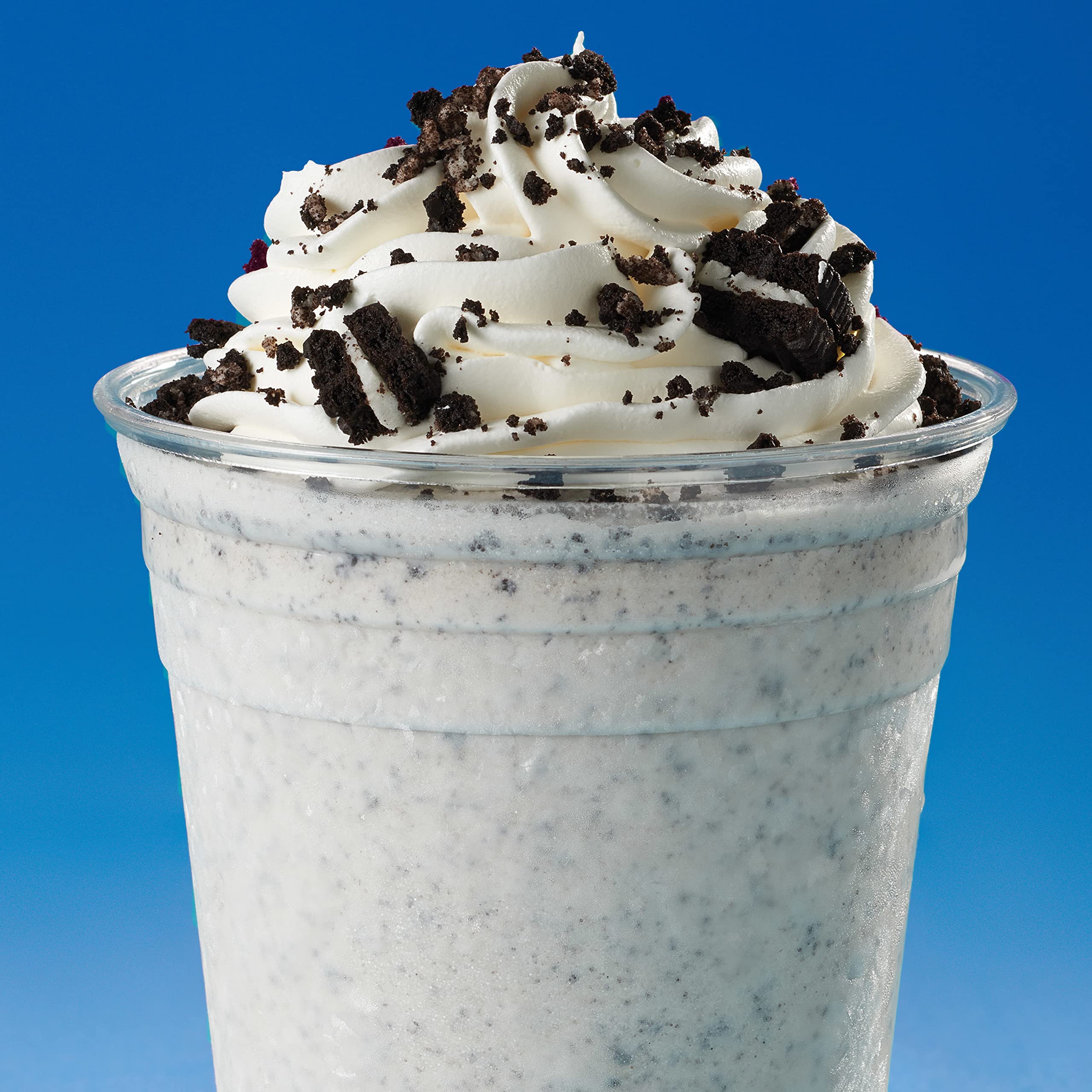 OREO cookies being dunked into a glass of milk