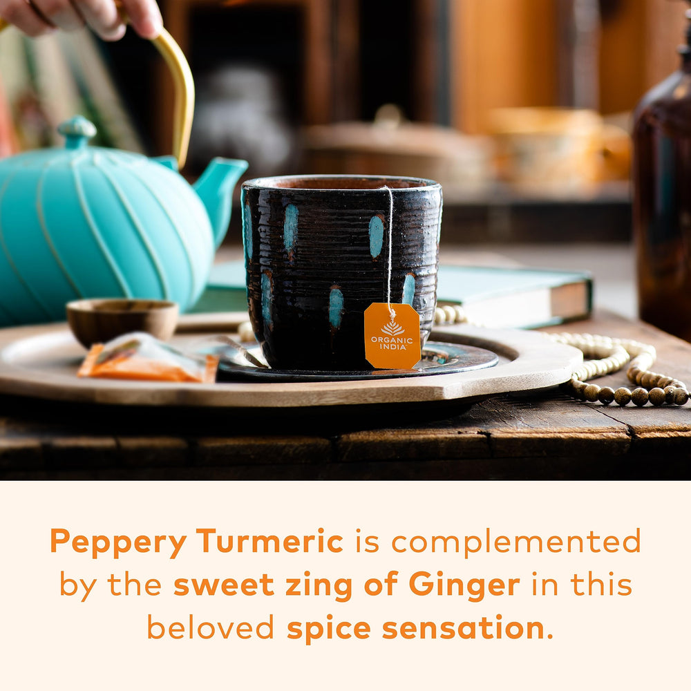 Warm cup of ORGANIC INDIA Tulsi Turmeric Ginger tea with spice aroma.