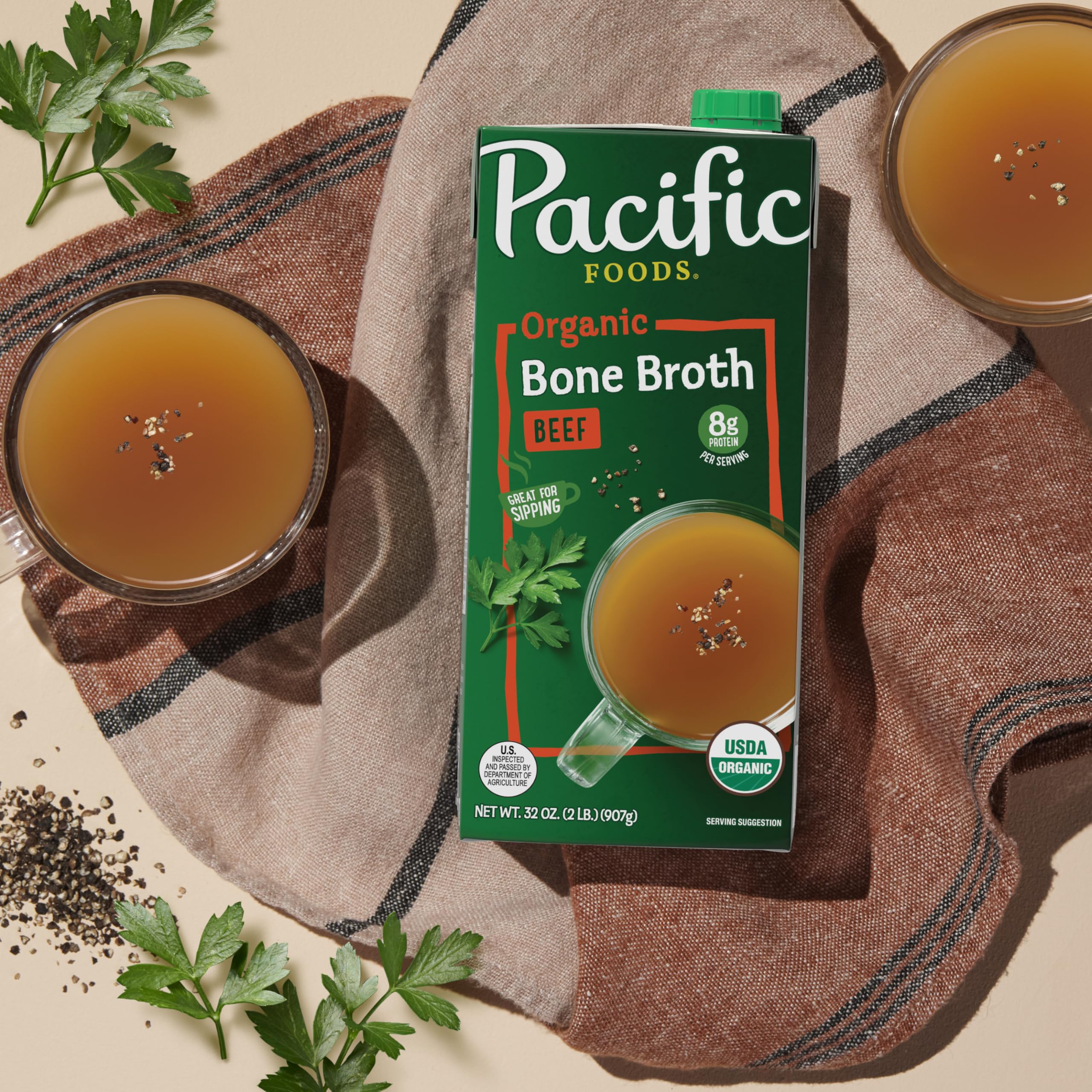Steaming bowl of bone broth with herbs for tasting.