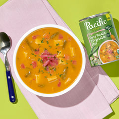 Pacific Foods Organic Curry Potato and Vegetable Soup being poured into a bowl for easy dinner.