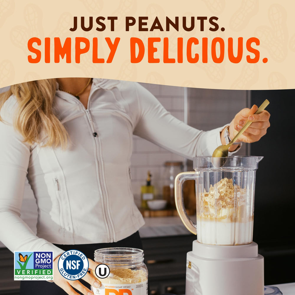 Pouring PBfit Simply Peanut Powder into a shake for creamy texture
