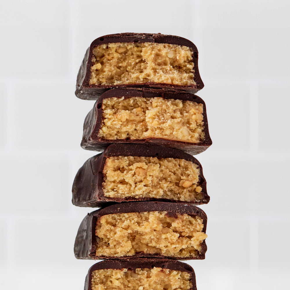 Close-up of Perfect Bar Mini chocolate-coated peanut butter bar highlighting creamy texture.