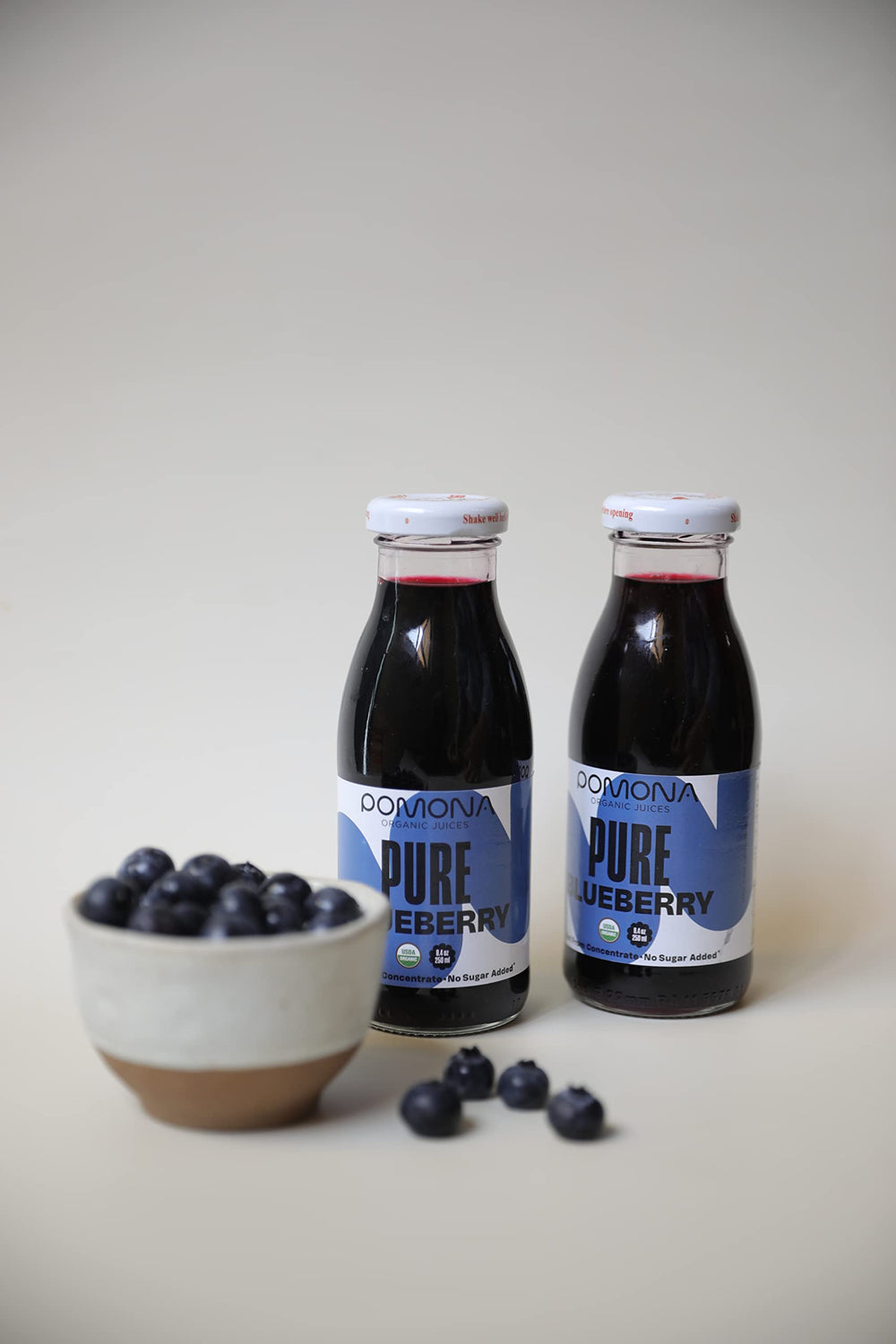 Pomona Blueberry Juice packaging highlighting glass bottle and sustainability.