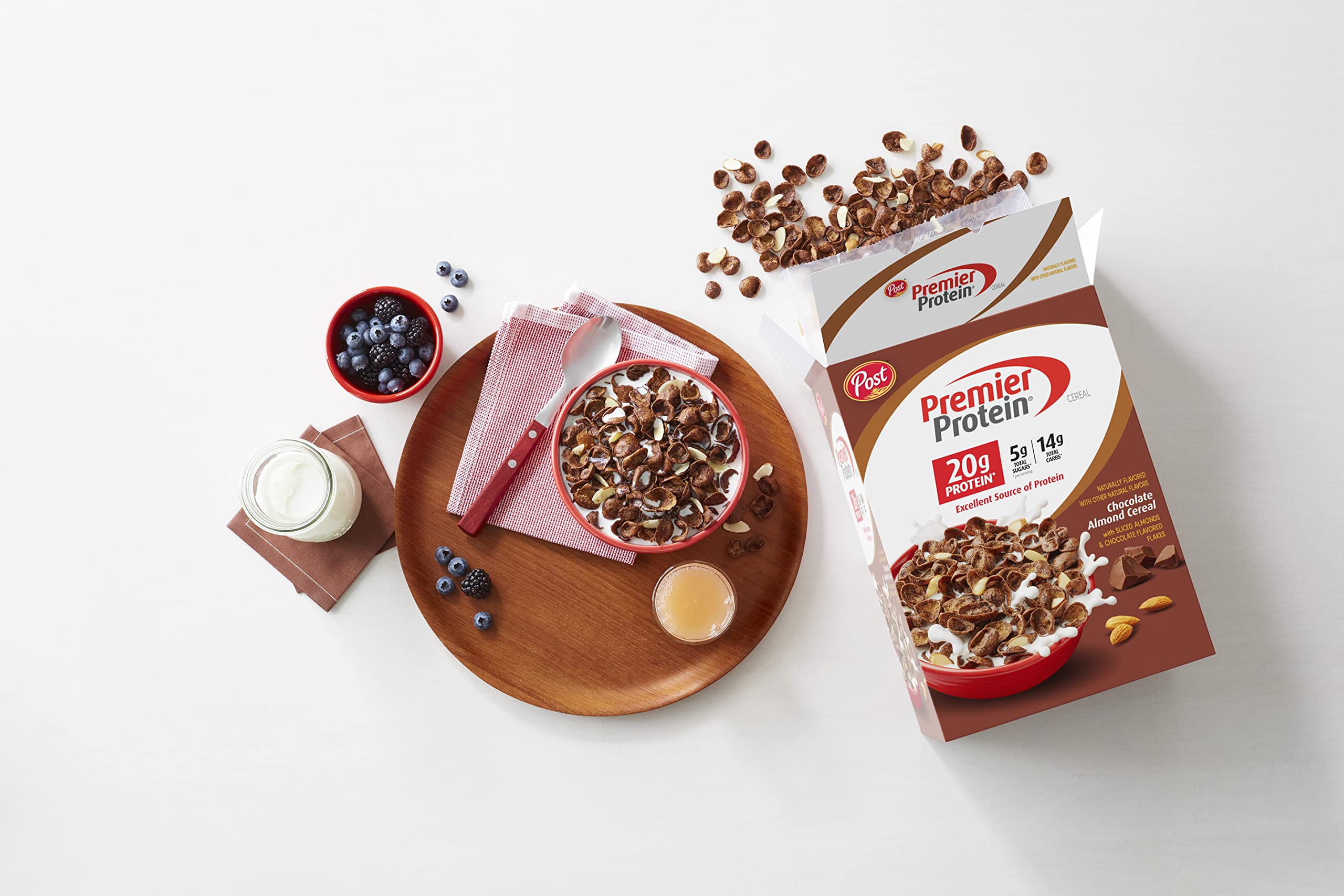 Premier Protein Chocolate Almond Cereal box and spoon on kitchen counter for breakfast.