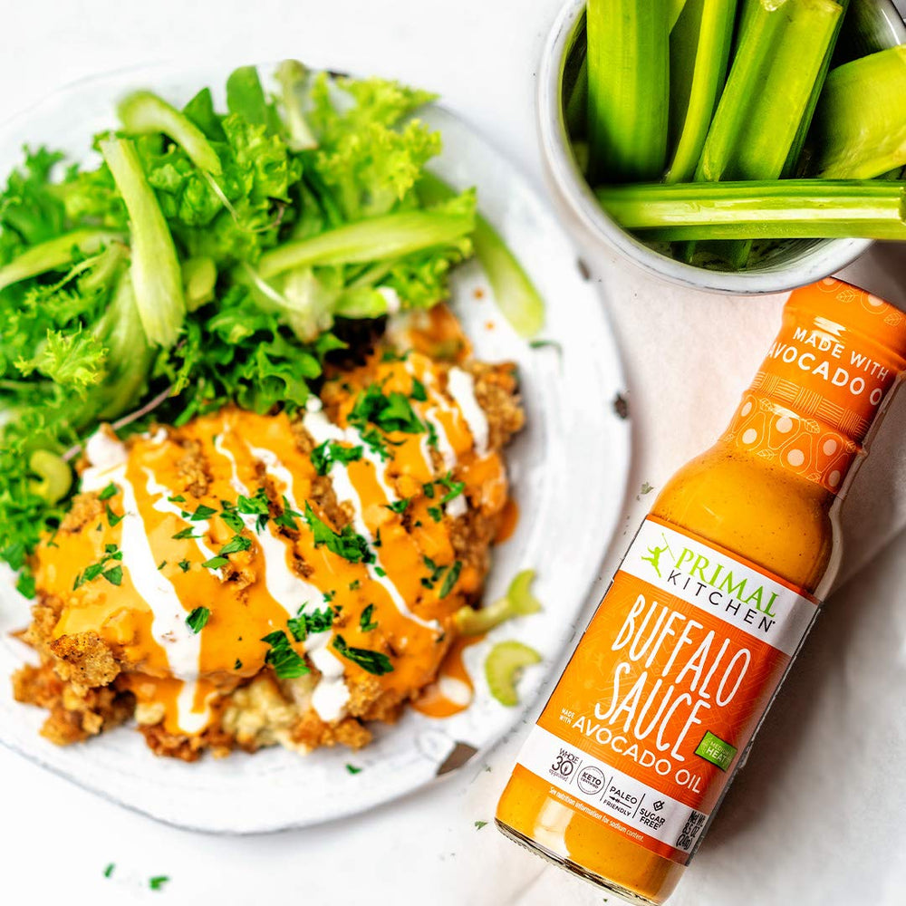 Primal Kitchen Buffalo Sauce pizza-topping, spicy finish for flavor layers.