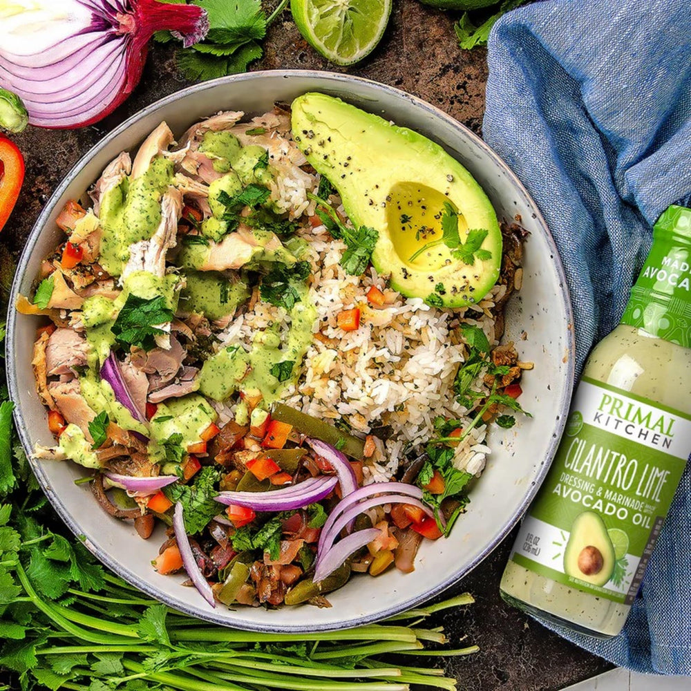 Primal Kitchen Cilantro Lime Dressing bottle shown with a glass for serving.