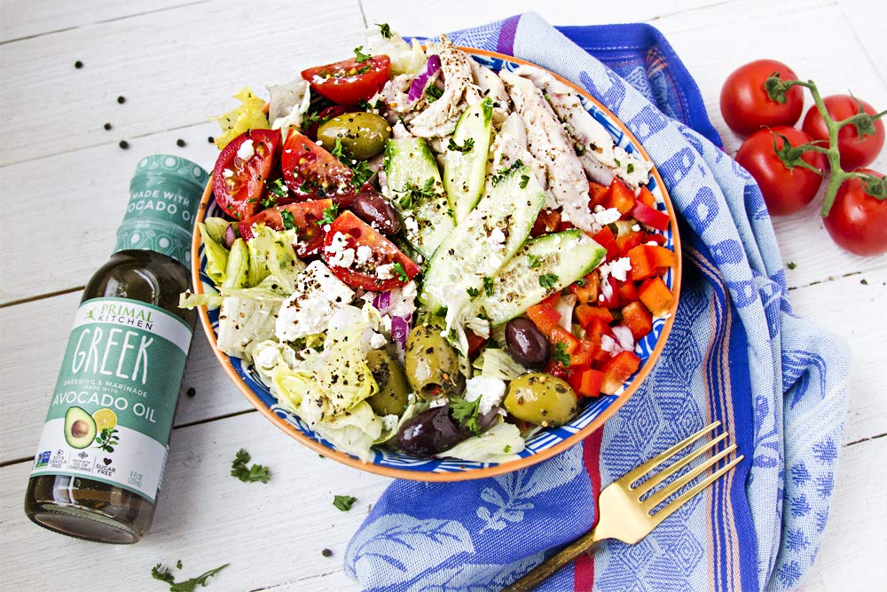 Primal Kitchen salad bowl with dressed greens showcases vibrant vinaigrettes.