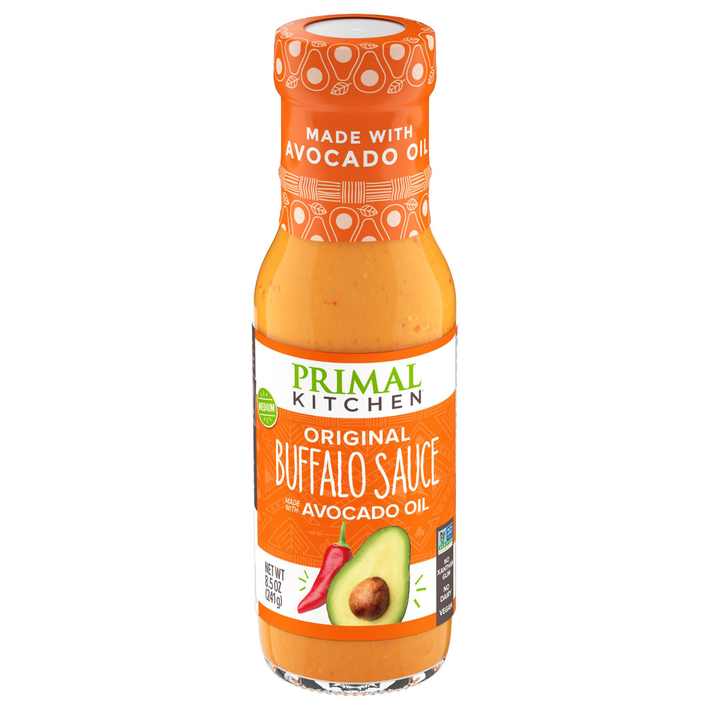 Primal Kitchen No Dairy Buffalo Sauce bottle pour shows creamy, dairy-free heat for wings
