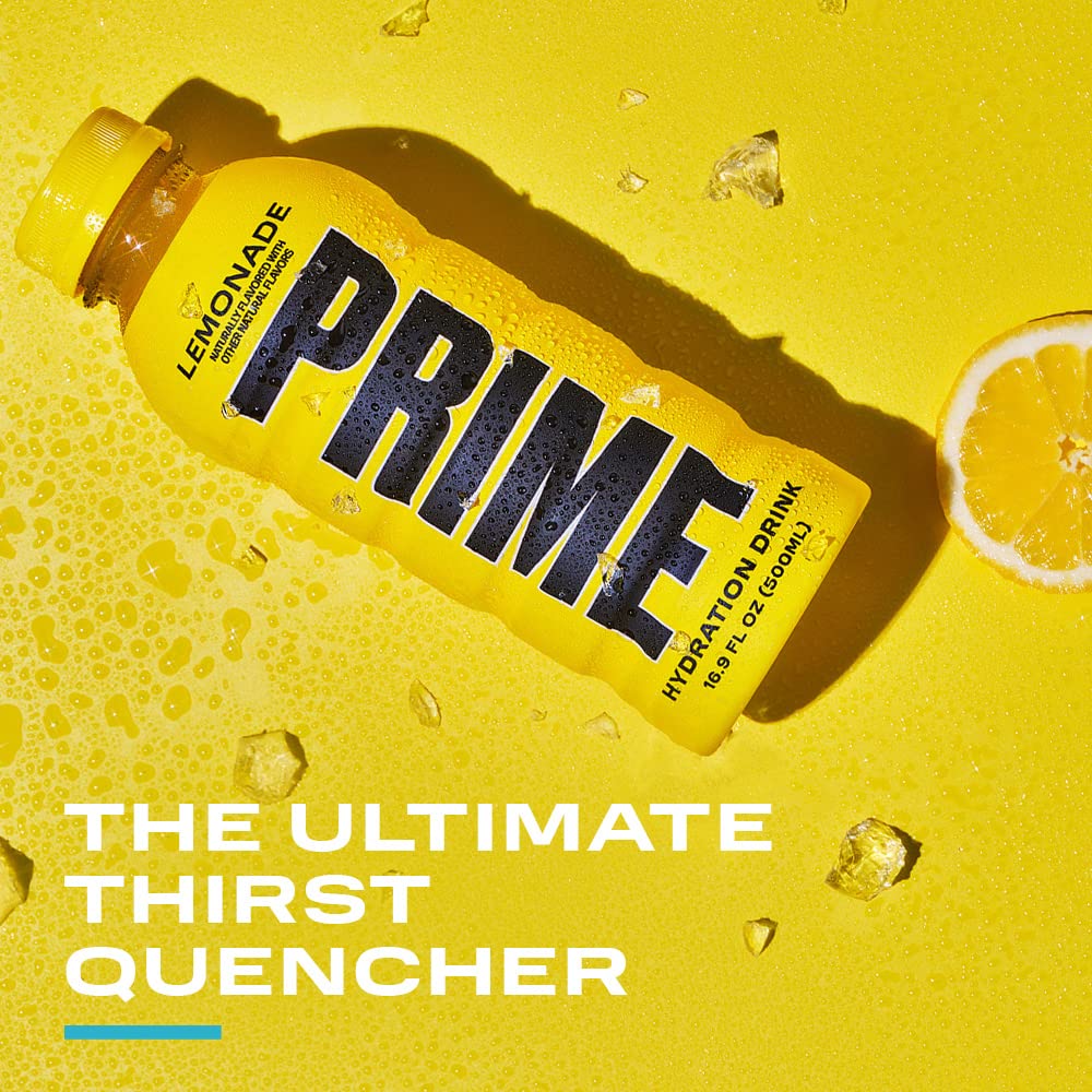 Fresh lemon wedge beside PRIME Hydration Lemonade bottle for a zesty sip.
