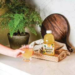 Fresh ginger root beside Prince Of Peace bottle for natural ingredients