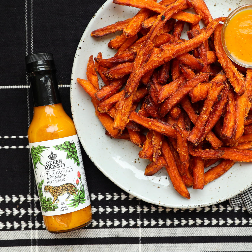 Queen Majesty glass bottle on table suggests premium, artisanal hot sauce.