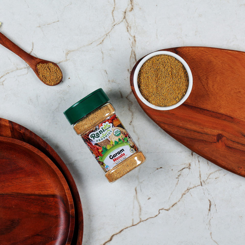 Rani Organic Garam Masala spice blend ready to season curries from a wooden bowl.