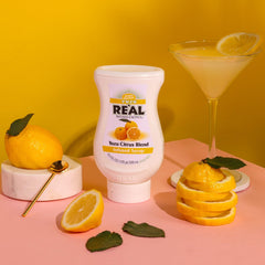 Reàl Infused Exotics Yuzu Syrup on a cocktail glass for citrus balance.