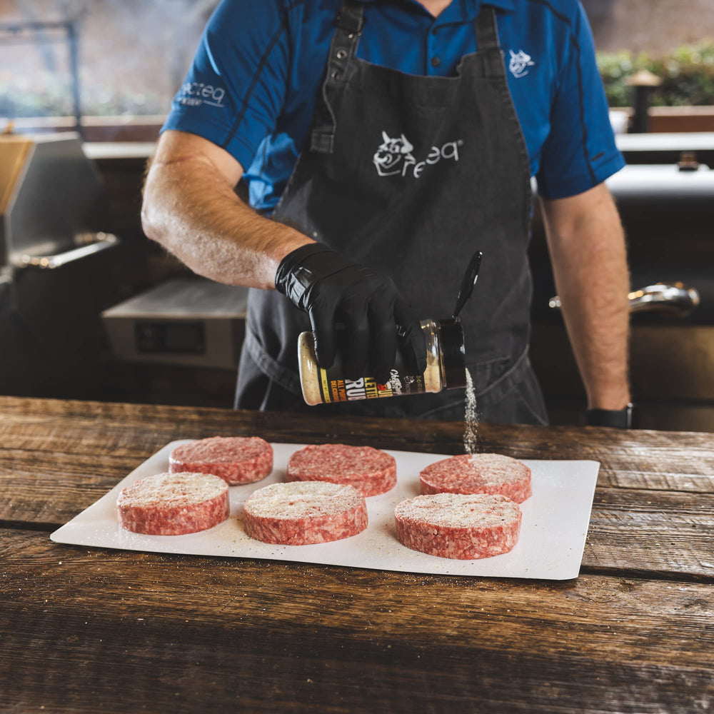 Sprinkling recteq Chef Greg's 4 Letter Rub for even seasoning on grilled foods.