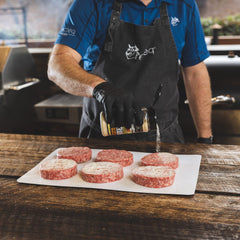 Sprinkling recteq Chef Greg's 4 Letter Rub for even seasoning on grilled foods.