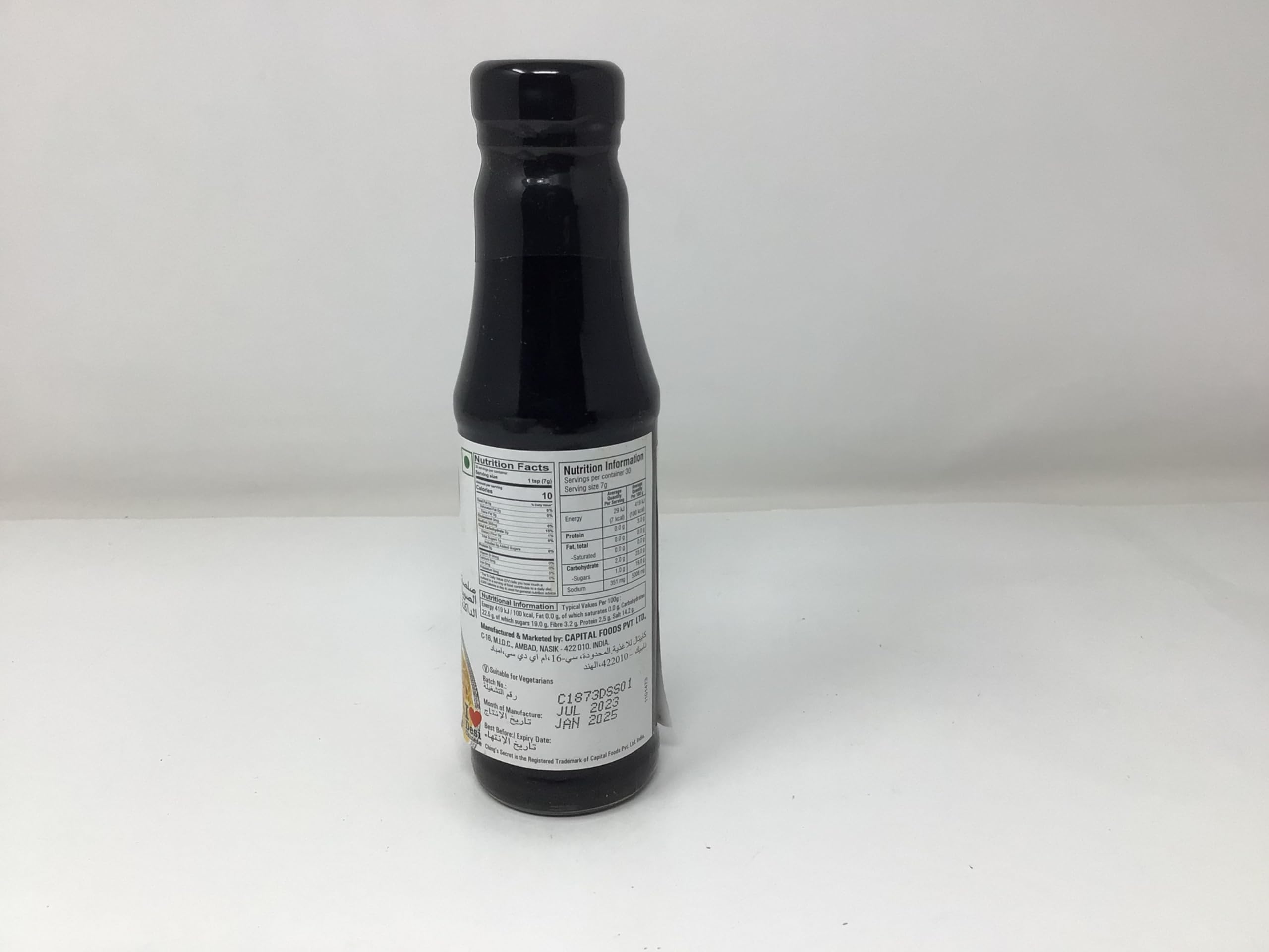 Glass bottle of Chings Dark Soy Sauce with a steady pour.