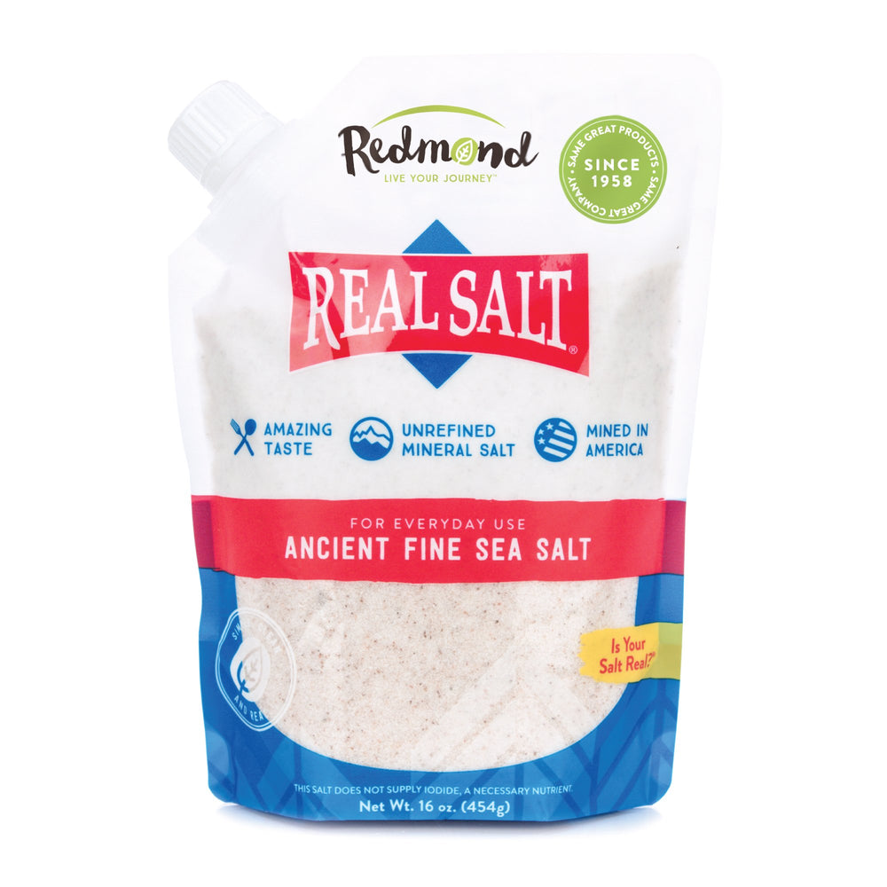 Redmond Real Salt bottle being poured for vibrant cooking flavor.