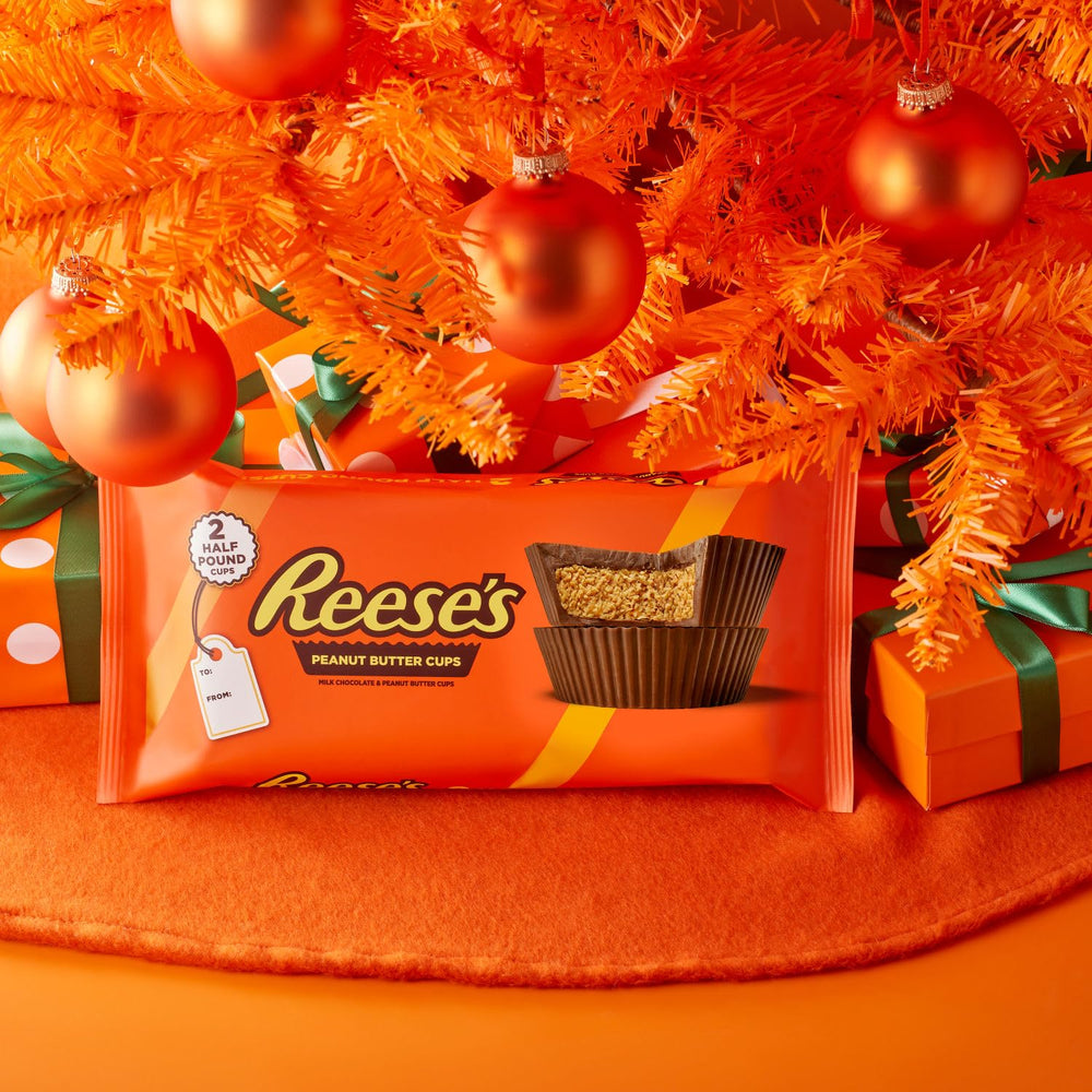 REESE'S Milk Chocolate Peanut Butter Cup Bar broken piece reveals smooth peanut butter filling.