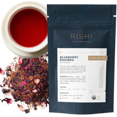 Rishi Blueberry Rooibos loose-leaf tea with amber brew and blueberries for a fruity caffeine-free sip.