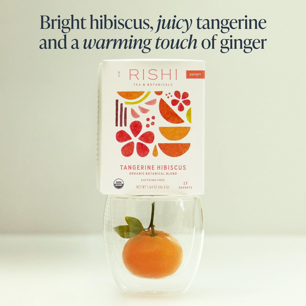 Warm cup with steam showing vibrant hibiscus and tangerine flavors.